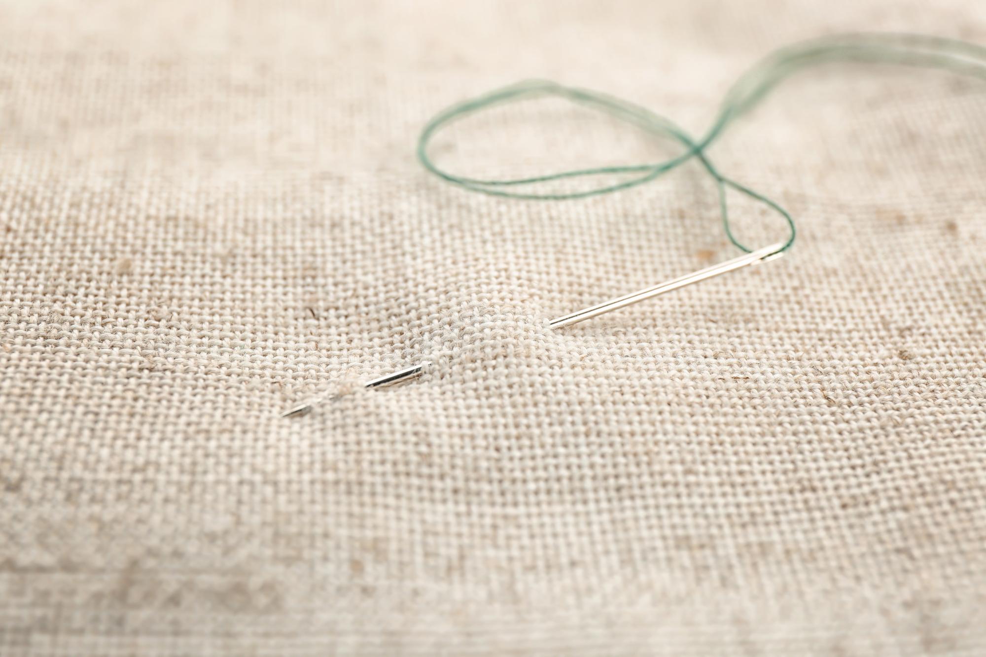 Close-up of hand embroidery on linen with soft thread tones