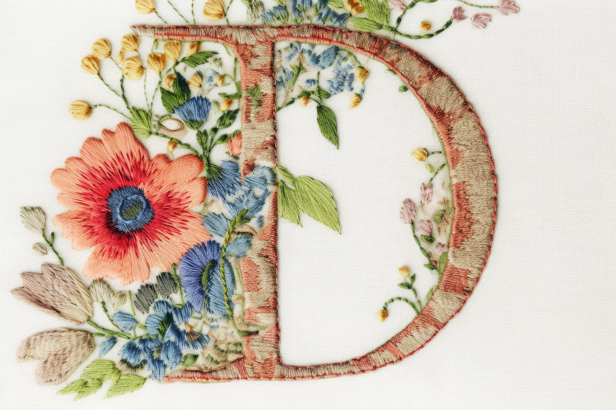 Small embroidered patch with initials and floral detail
